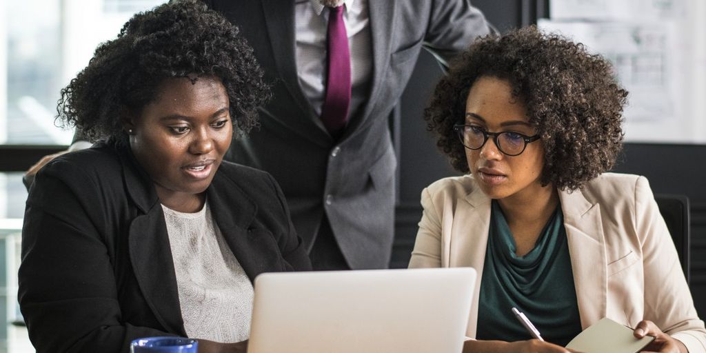 business professionals analyzing financial data on computer in modern office